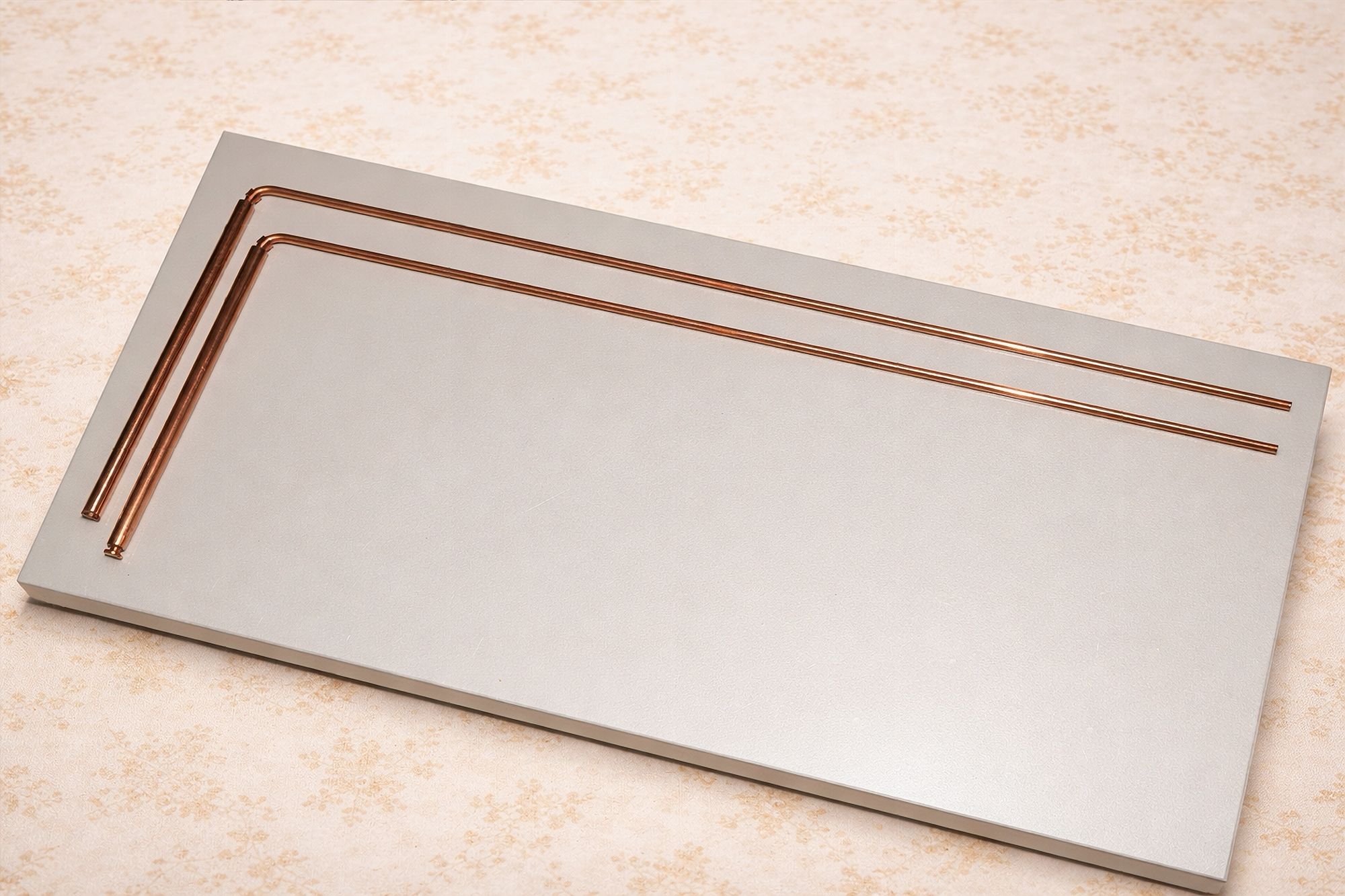 The pair of copper dowsing rods presented on a pale board